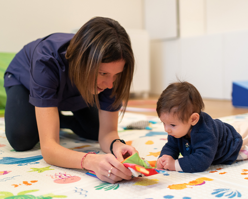 Terapista della neuropsicomotricità durante una seduta dedicata allo sviluppo del bambino.